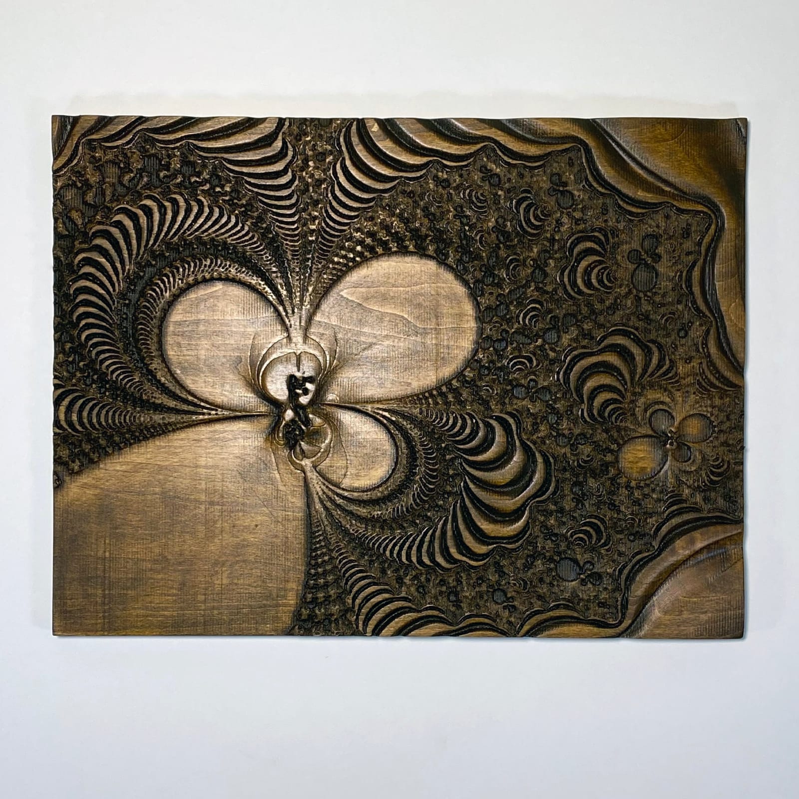 Crucible — a deep zoom into the Mandelbrot set boundary, CNC carved in relief into stained aspen